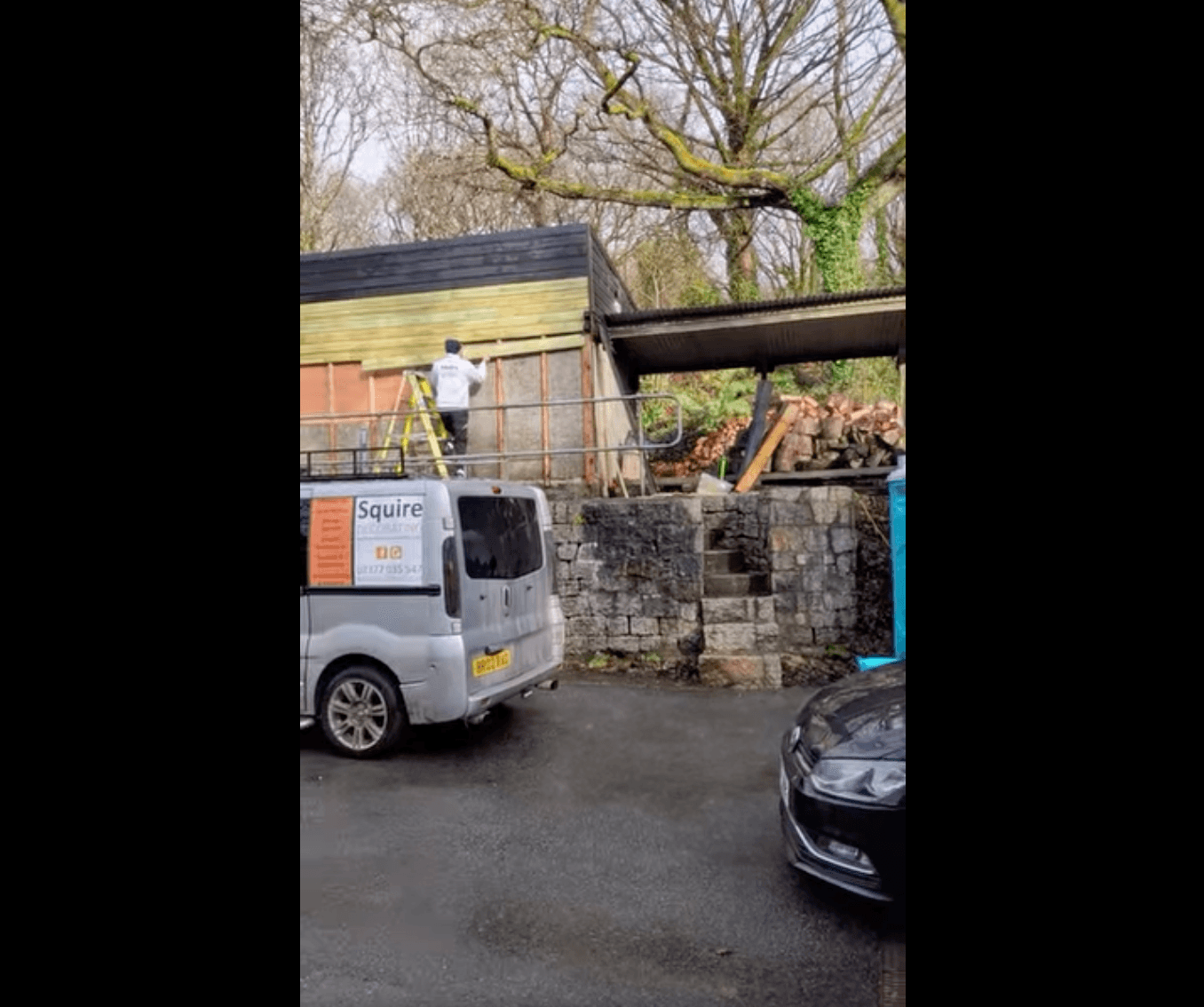 Branded Squire Decorating van parked beside a timber-clad outbuilding mid-build with a ladder leaning up.