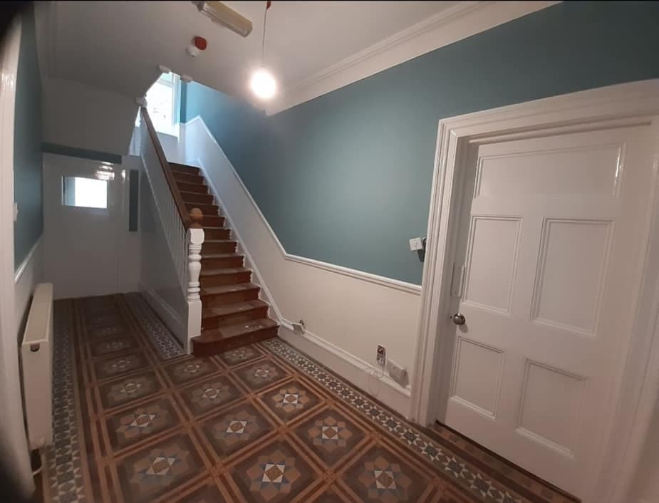 Period hallway with original Victorian patterned floor tiles and timber stairs.